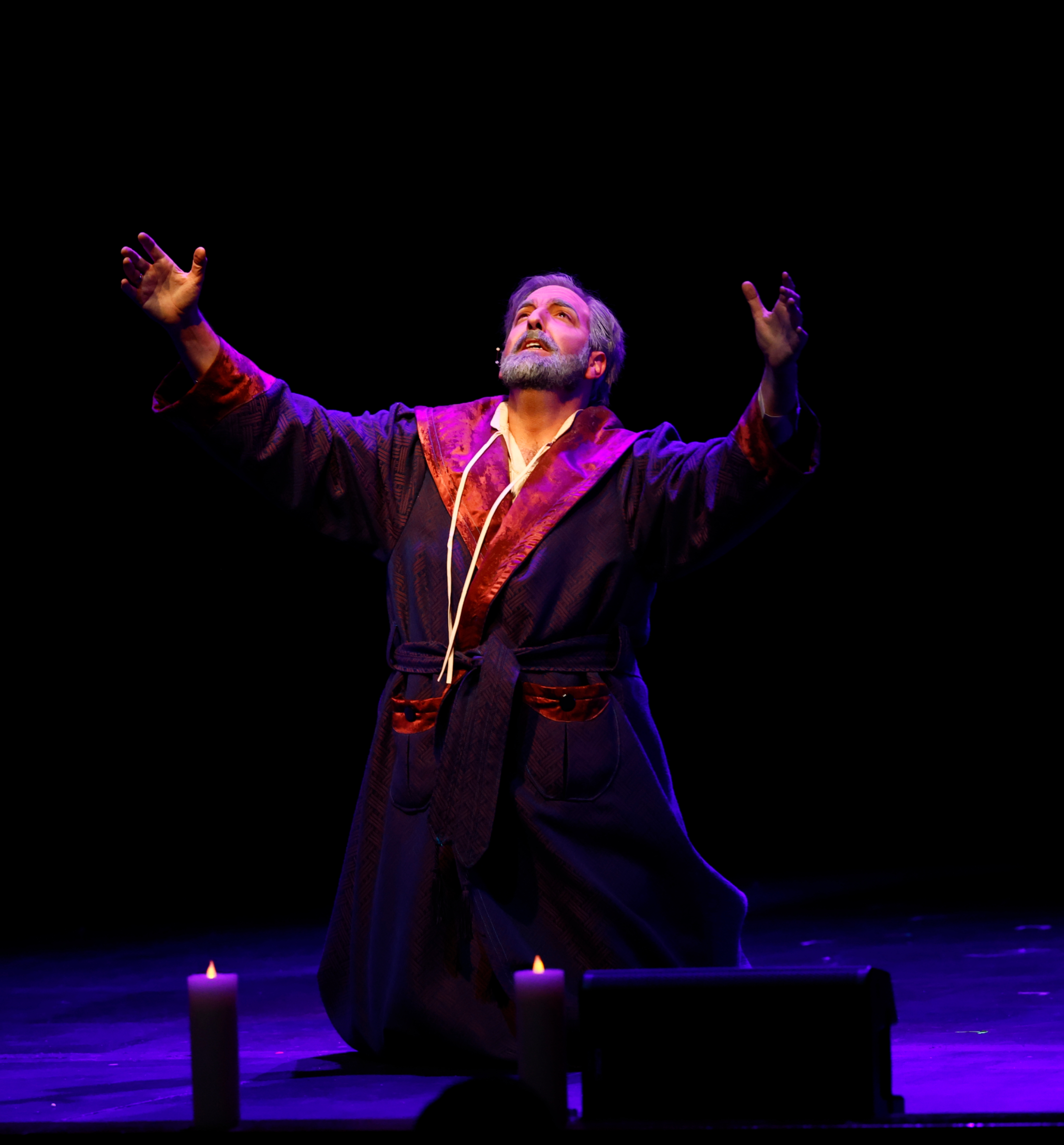 Scrooge on his knees in candlelight